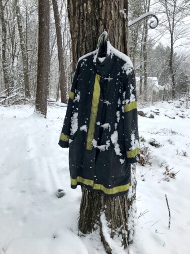 Fire gear hanging on tree in snow